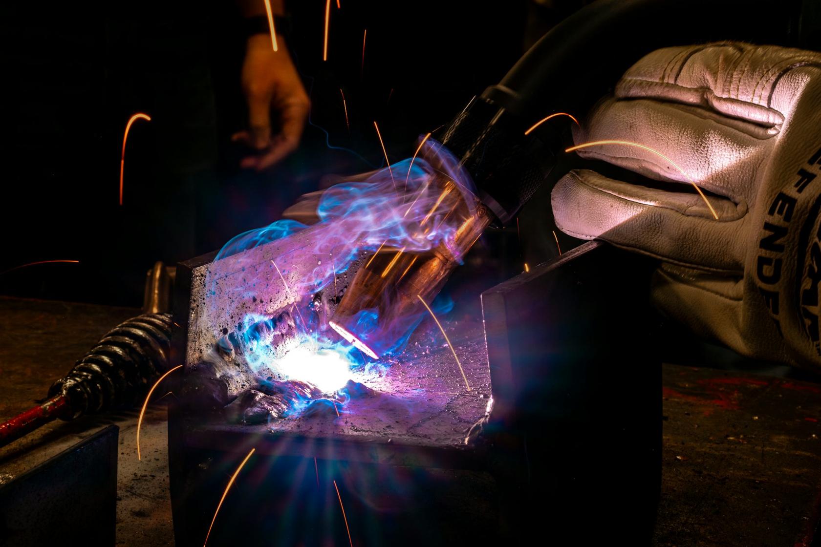 Welder fabricating steel with sparks